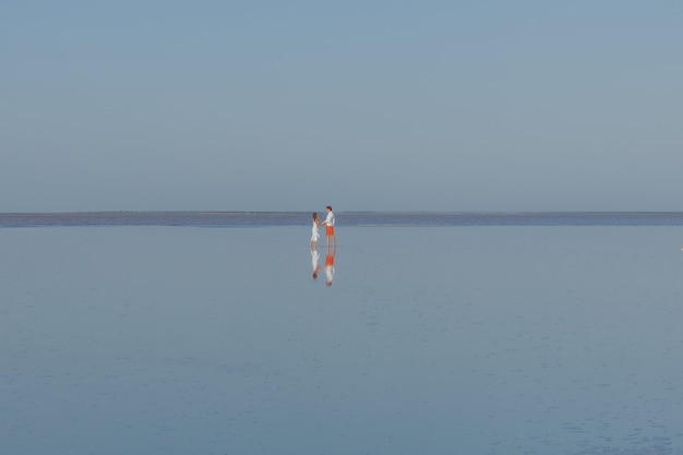 Een man en een vrouw lopen op het gladde water van het meer