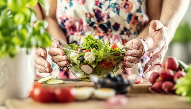 Een man en een vrouw maakten een gezonde lentesalade Samen houden ze met hun handen een kom gezond eten vast