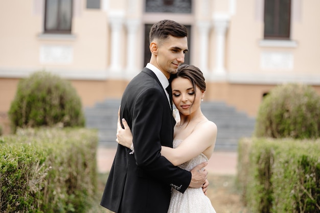 Een man en een vrouw omhelzen zich voor een gebouw.