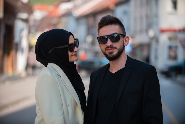 Een man en een vrouw staan op straat met een zonnebril op en een vrouw met een zonnebril op.