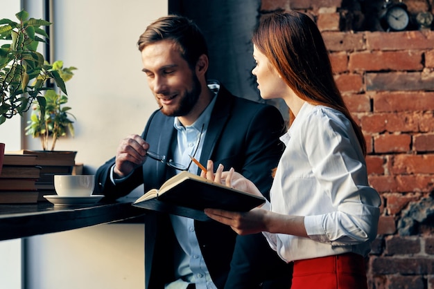 een man en een vrouw zitten aan een tafel in een café werken communicatie professionals hoge kwaliteit foto