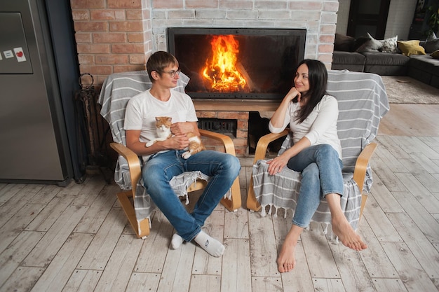 Een man en een vrouw zitten bij de open haard Romantische avond