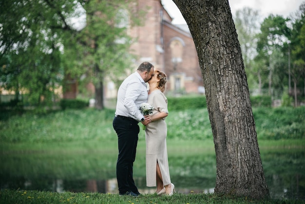 Een man en een vrouwenpaar in het park zoenen