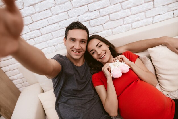 Een man en een zwangere vrouw maken selfie.