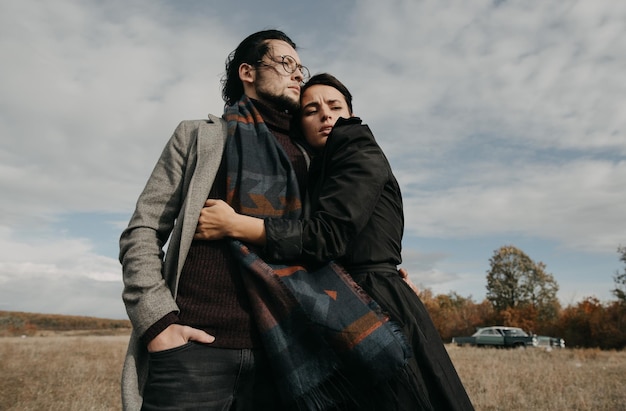 Een man en vrouw knuffelen in een veld