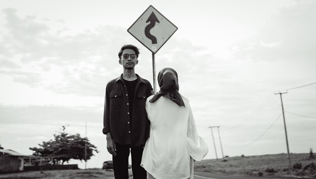 Foto een man en vrouw staan onder een straatnaambord waarop staat 'ik ga naar rechts'