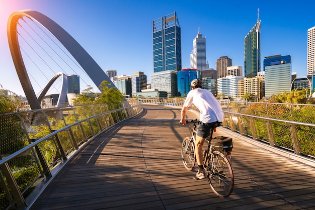 Een man fietsen op een Elizabeth Bridge in de stad Perth