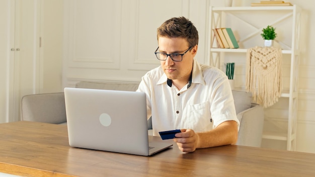 Een man gebruikt een laptop voor online winkelen thuis aankoopbevestiging via internet