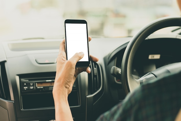 Een man gebruikt een smartphone met een leeg scherm tijdens het autorijden