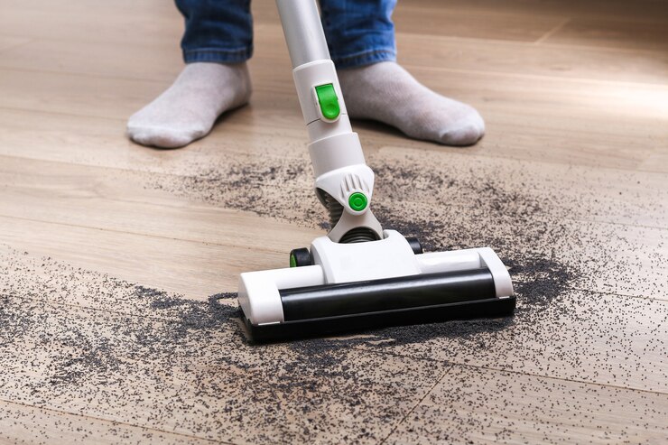 Foto een man gebruikt een zakloze verticale draadloze stofzuiger om de vloer schoon te maken.