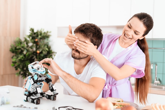 Een man haalt een robot op in de keuken.