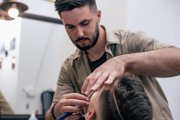 Een man hangt rond in een schoonheidssalon. Kapsel en styling in kapperszaak. Mannenverzorging voor baard en haar.