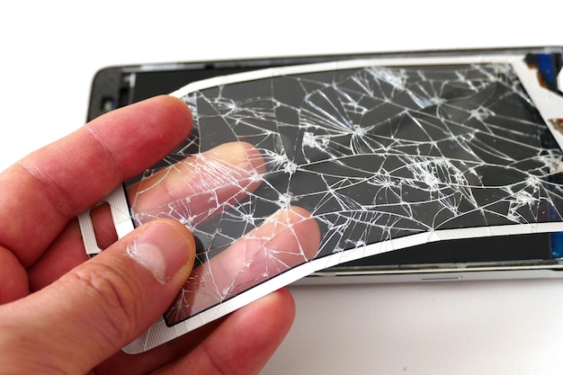 Een man heeft gebroken en gebarsten telefoonschermglas in zijn hand