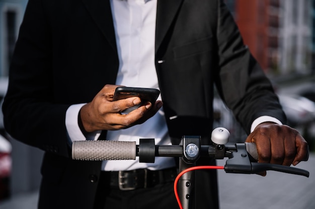 Een man houdt een elektrische scooter achter het stuur Ecotransport maakt ook foto's