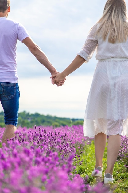 Een man houdt een meisje bij de hand in een lavendelveld Selectieve focus