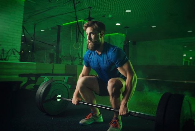 Een man in de sportschool duwt de lat