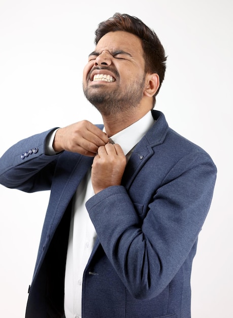 Een man in een blauw pak knoopt zijn stropdas.