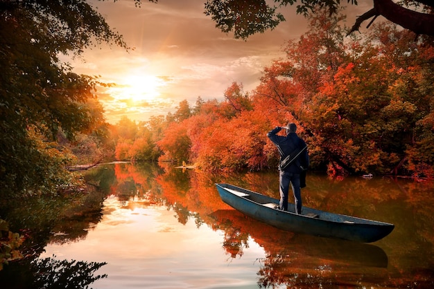 Een man in een boot op de rivier in de herfst