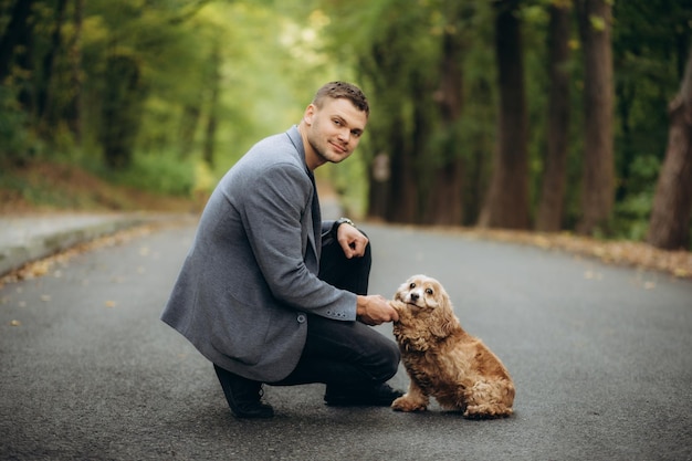 Een man in een jas loopt met een hond.