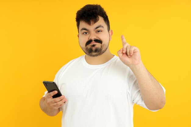 Een man in een lichaam met een telefoon in zijn handen op een gele achtergrond
