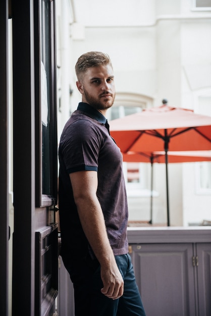 Een man in een paarse polo en poseren voor reclame voor herenkleding. Schieten voor herenkledingwinkel