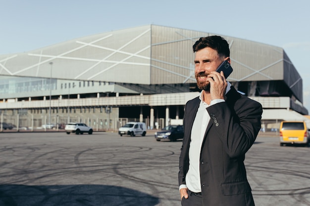 Een man in een pak praat aan de telefoon in de buurt van het kantoorcentrum