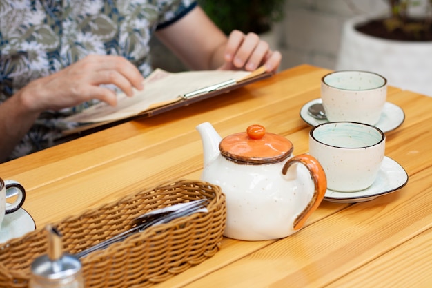 Een man in een restaurant leest het menu en drinkt thee