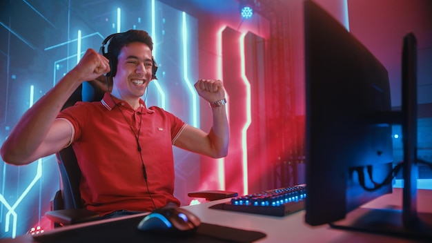 Een man in een rood shirt speelt een spelletje op een computer.