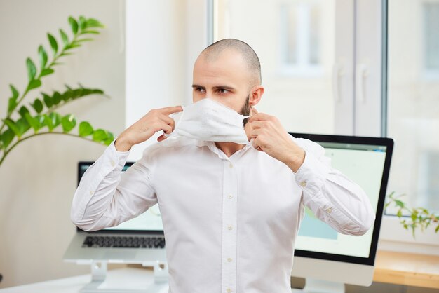 Een man in een shirt zetten een gezichtsmasker