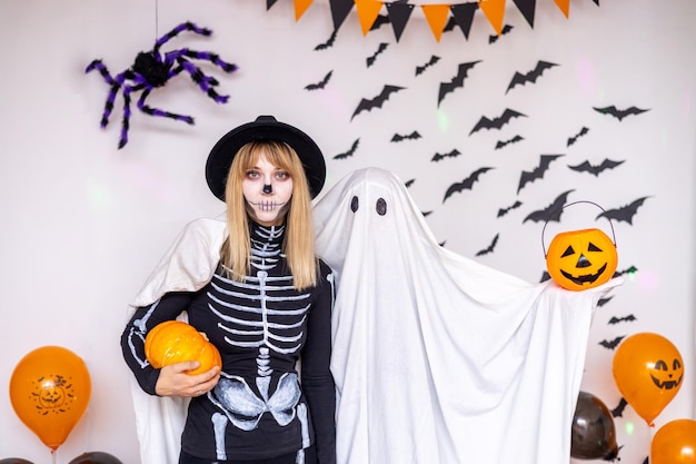 Een man in een spookkostuum en een vrouw in een skeletkostuum op Halloween
