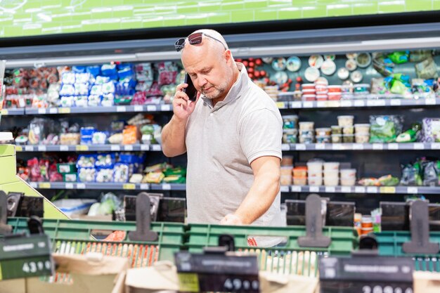 Een man in een supermarkt met een telefoon