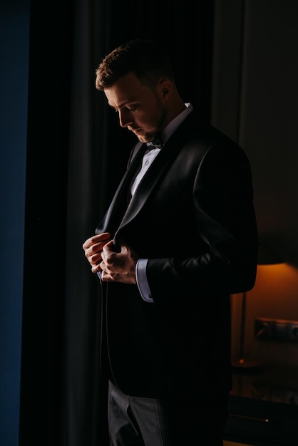 een man in een tuxedo staat voor een lamp