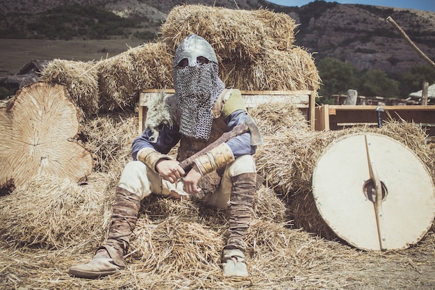 een man in een Viking-kostuum zit op een hooi