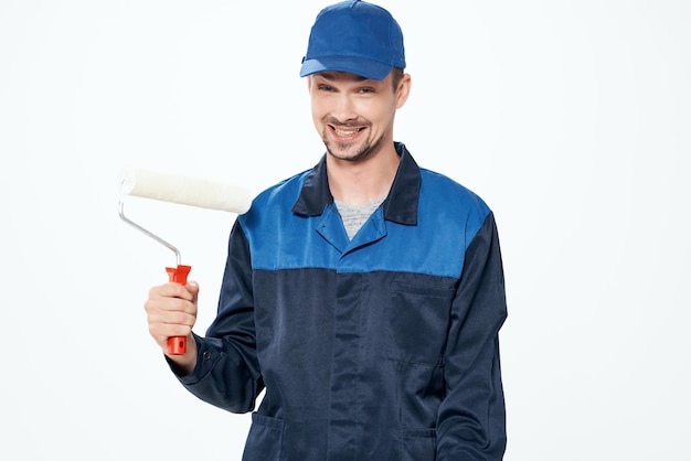 Een man in een werkuniform die de muren schildert en het huis repareert