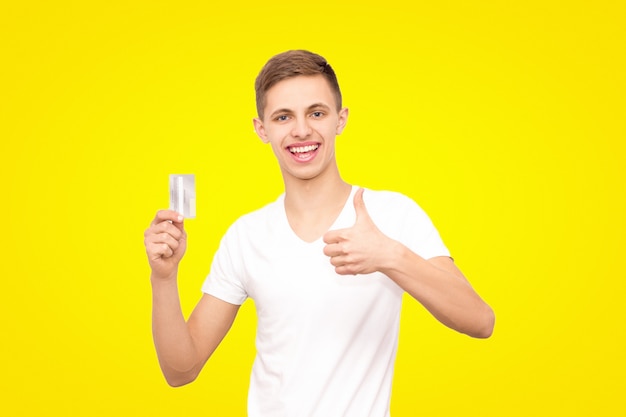 Een man in een wit T-shirt met een creditcard en eenhandig gebaar van een klas