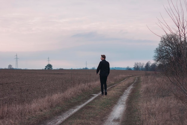 Een man in een zwart pak rent over het veld