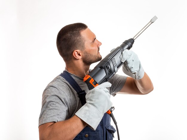 Een man in robo-achtige kleding houdt een handstempel vast, klaar om te werken, op een witte achtergrond.