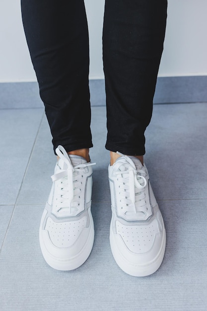 Een man in witte leren casual sneakers zomer heren sneakers Man in zwarte jeans