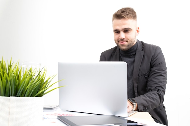 Een man in zakelijke kleding werkt aan een tafel op een laptop