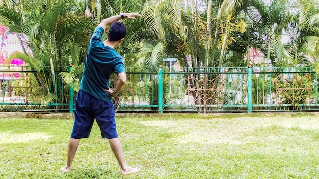 Een man is aan het sporten in een met gras begroeid park