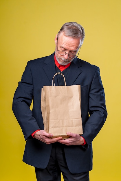 Een man kijkt naar een papieren zak die een cadeau ontvangt.