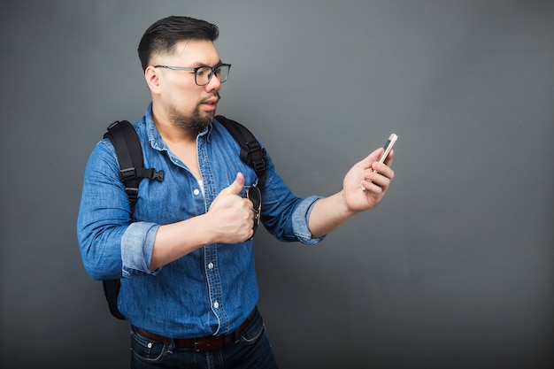 Een man kijkt verbaasd naar de telefoon