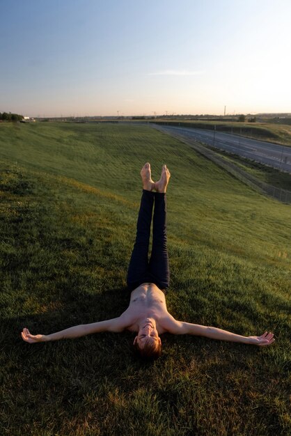 Een man ligt op het gras met zijn armen uitgestrekt.