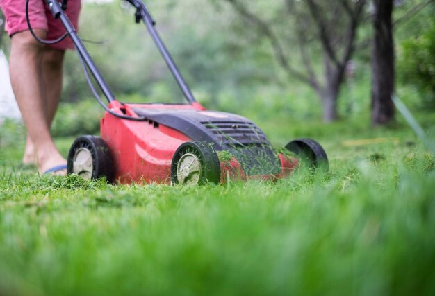 Een man maait het gras met een grasmaaier