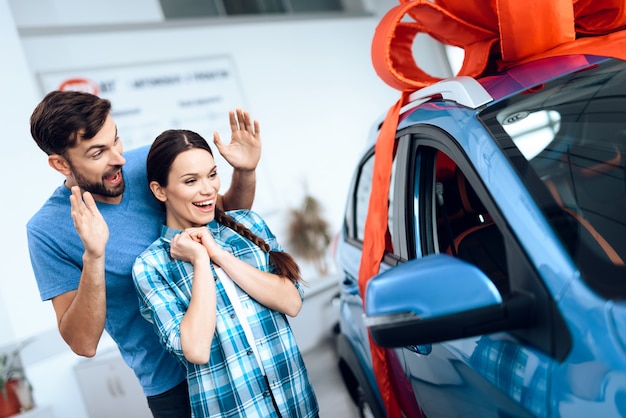 Een man maakt een geschenk - een auto voor zijn vrouw.