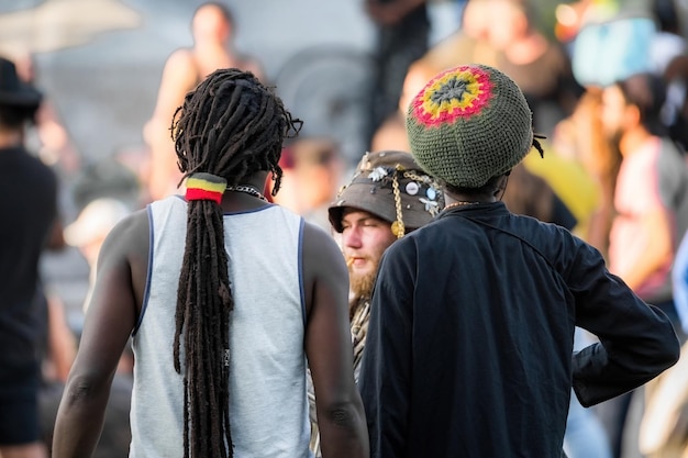 Een man met dreadlocks en een hoed met een rode cirkel erop