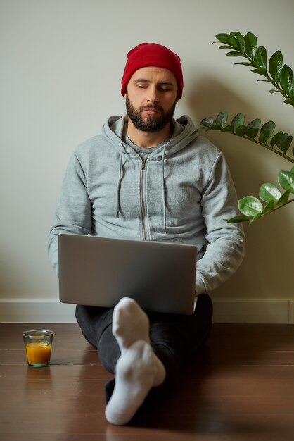 Een man met een baard die op zijn laptop werkt