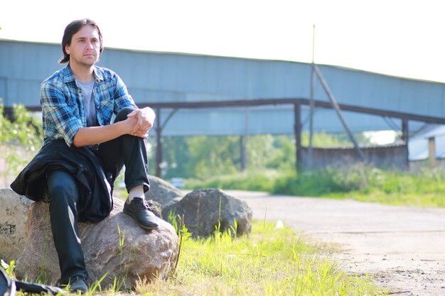 Een man met een baard en in spijkerbroek staat in de industriële zone