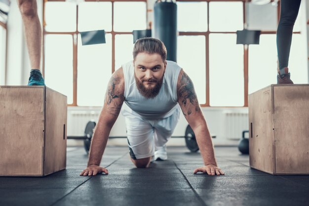 Een man met een baard oefent in de sportschool.