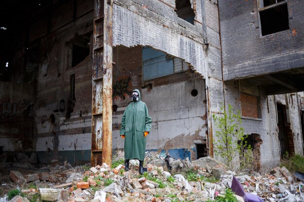 Een man met een beschermend masker en beschermende kleding onderzoekt de gevarenzone Ecologische catastrofe Gevaarlijke giftige zone